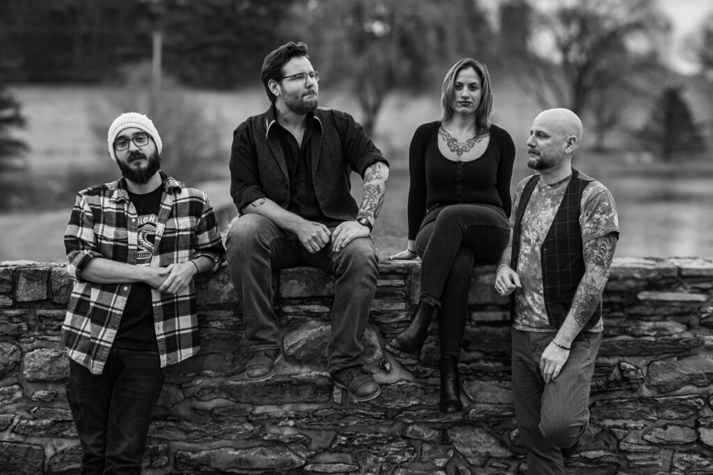 Photo of stoner doom band Bellwether Ritual sitting and standing on a brick wall at Riverton Records studio